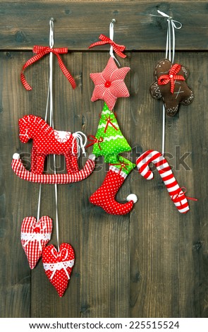christmas decoration handmade toys hanging over rustic wooden background. nostalgic retro style toned picture