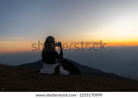 Asian woman Nature photographer,Beautiful background at sunset
