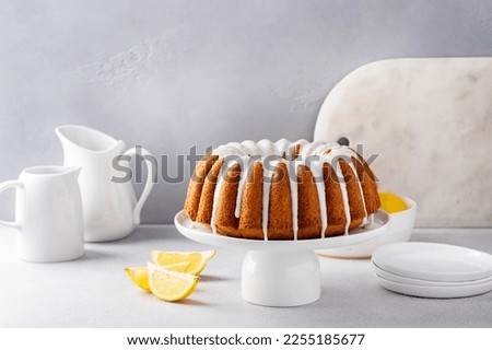 Lemon bundt cake drizzled with powdered sugar glaze on a cake stand Royalty-Free Stock Photo #2255185677