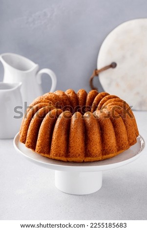 Vanilla bundt cake on a cake stand, golden freshly baked ready to eat