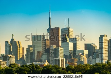 Toronto skyline at warm summer. Toronto, Ontario, Canada. Panoramic view of Toronto skyline near Ontario lake at sunset at scattered clouds.