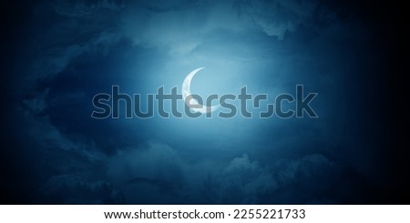 Crescent moon among the clouds in the midnight sky. Royalty-Free Stock Photo #2255221733