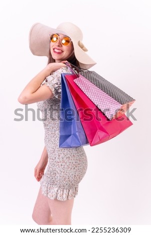Attractive woman holding shopping bags on white background with copyspace