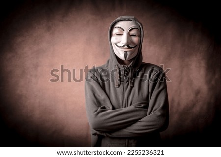 Man with anonymous mask with sweatshirt, looking at camera, studio shot Royalty-Free Stock Photo #2255236321