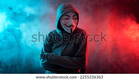 Hacker with anonymous mask with arms crossed with a menacing look Royalty-Free Stock Photo #2255236363