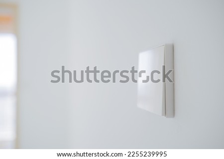 Light switch on white wall in room