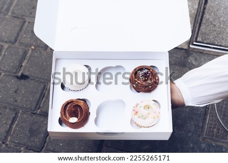 Assorted Gourmet Tasty Cupcakes on a White Cardboard Box to Take Away. Overhead view
