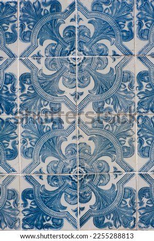 Vintage ceramic tiles of blue colour with floral repetitive ornate in Lisbon, Portugal. Authentic Portuguese tiling art. Vertical photo.
