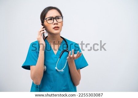 Portrait of Asian female doctor with stethoscope talking on mobile phone isolated on white background.
