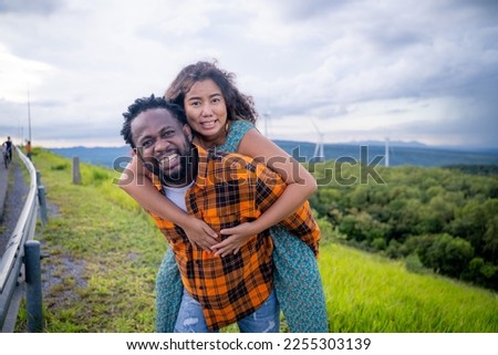 Couple in love in the background of wind turbine power plants.
