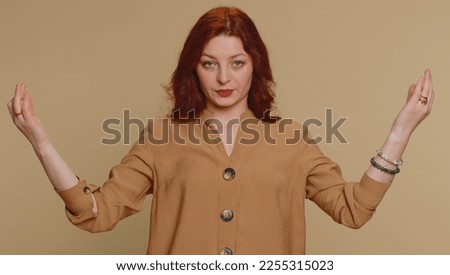Keep calm down, relax, inner balance. Redhead woman breathes deeply with mudra gesture, eyes closed, meditating with concentrated thoughts, peaceful mind. Young ginger girl on beige studio background