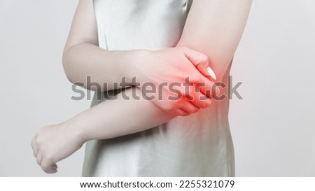 young woman experiencing pain in elbow joint Royalty-Free Stock Photo #2255321079