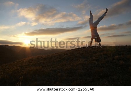 Acrobatic girl on grassland of sunrise