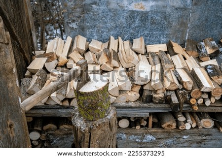 Ax stuck in a log. A pine log cut in half. Preparation of firewood