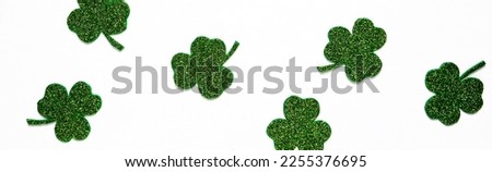 Happy St. Patrick's Day banner.Holiday background.St Patricks Day frame against a white background. Flat lay shamrocks.Copy space.Patrik's day banner Royalty-Free Stock Photo #2255376695