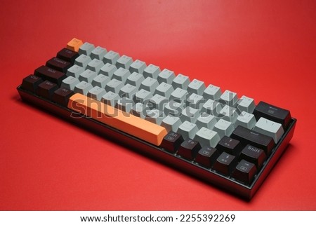Mechanical keyboard with colorful keys and minimalist design on red background isolated Royalty-Free Stock Photo #2255392269