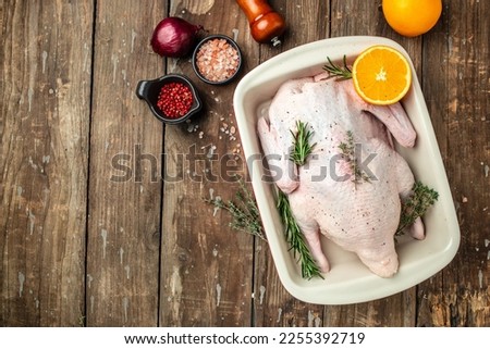 Raw free range duck with spices ready to cook on a wooden background, Culinary cooking. banner, menu, recipe place for text, top view,