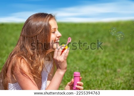 happy girl with soap bubbles in nature