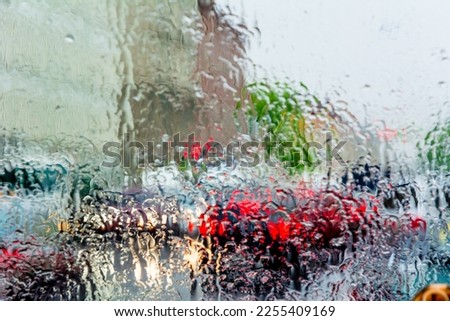 Bad weather, rain, street traffic photographed through wet glass.
