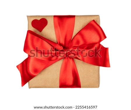 Wrapped gift box with red ribbon bow isolated on white background. Valentine's Day. Close-up. Top view. Flatlay. Selective focus.