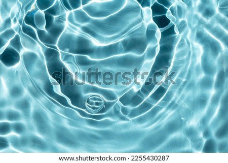 Light blue water with waves and ripples. Textured background for your design. Pool, river, ocean. Selective focus, defocus