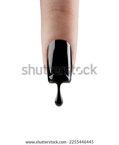 Nail art finger nail. Black gel polish dripping from beautiful long nail isolated on white background. Woman finger with dark manicure and drop of nail polish. Fashion art design