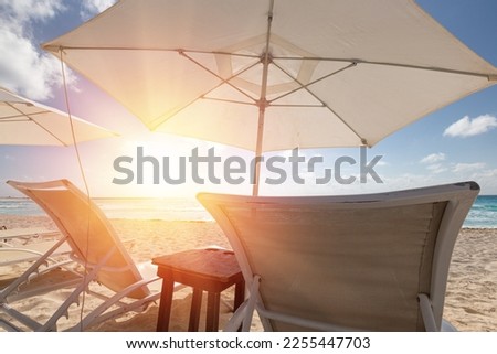 Sun umbrella ans sunbed on white sandy beach with turquoise ocean water. Caribbean sea travel destination. Bounty and pristine nature for vacation. Nobody Royalty-Free Stock Photo #2255447703