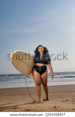 Plus size Black beautiful woman going surfing on the beach. Copy space. The concept of summer vacation body positivity holiday travel