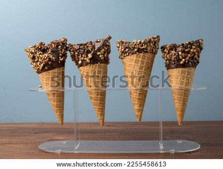 Chocolate dipped waffle cone with nuts Royalty-Free Stock Photo #2255458613