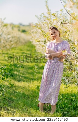 an attractive brunette woman in a lilac in a spring flowering garden. the concept of walking in the park. aromatherapy and perfumery. the beauty of nature.