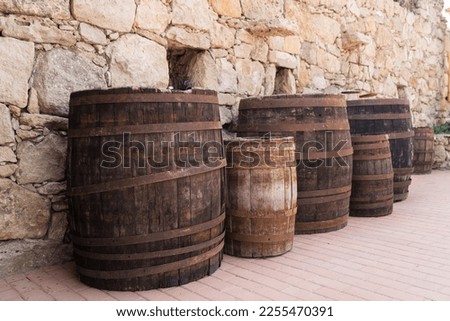Old wooden barrels on a real stone wall surface background