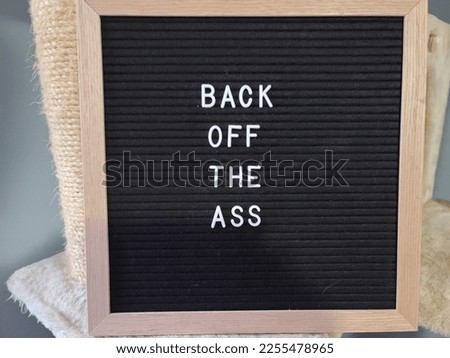 A sign saying back off the ass. The felt sign has removable letters than can be moved around to make whatever words or saying one wants. 