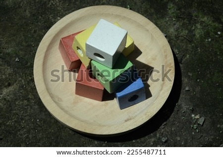several colorful toy box blocks placed on a wooden plate, Yogyakarta, Indonesia. shooting is done from a higher angle than the object or high angle