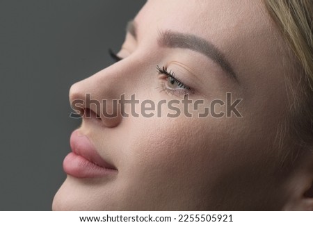 Young woman profile portrait, over grey background. Beauty female, model girl face close-up. Aesthetic medicine. Blonde model with perfect skin Royalty-Free Stock Photo #2255505921