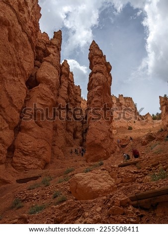 Scenic view of orange, red and white column rocks at Bryce Canyon National Park. Hiking path and hikers on Navajo Loop Trail amongst the hoodoos.