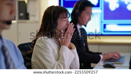 Female Asian cusomer service operator feels tired and yarning during work