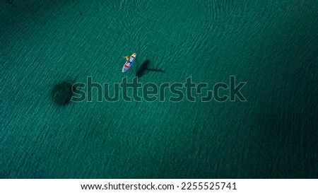 Aerial photo of surfer walking on sup board at calm clear lake