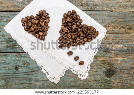 Two hearts made from coffee beans on  wooden  background. From a series Coffee time