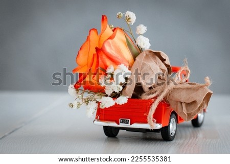 red pickup retro toy car delivering bouquet of flowers. February 14 card, Valentine's day. Flower delivery. 8 March, International Happy Women's Day.
