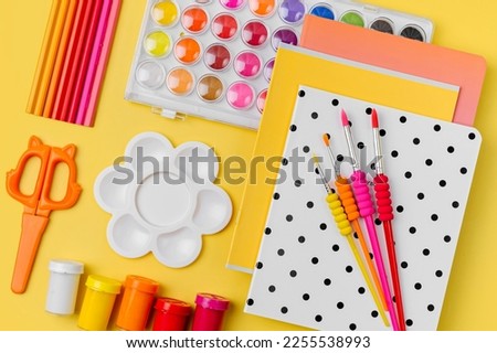 Various colorful material for creativity and art activity is arranged neatly on yellow background.  Stationery and supplies for drawing and craft. Workplace organization.    Royalty-Free Stock Photo #2255538993