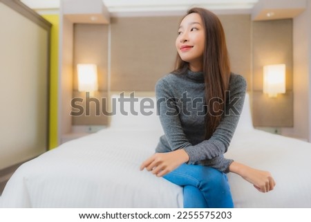 Portrait beautiful young asian woman relax smile leisure on bed in bedroom interior