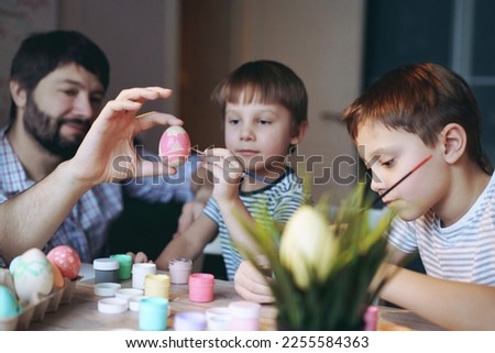 father and kids colouring eggs for easter. High quality photo