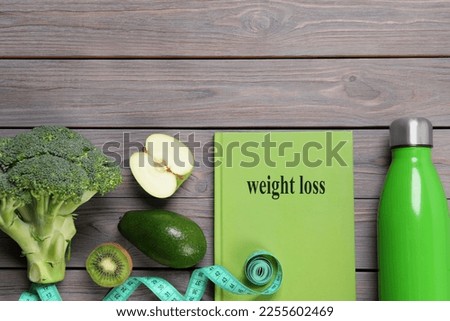 Weight loss concept. Flat lay composition with notebook, measuring tape and products on grey wooden table, space for text