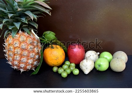 A Collection of winter fruits: Pineapple, Orange, Apple, Apple kul boroi, Chiku, Goose berry, Shankh Aloo.