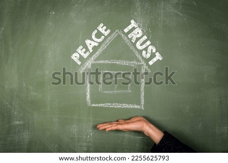 Peace and Trust concept. Text and house on green chalkboard.