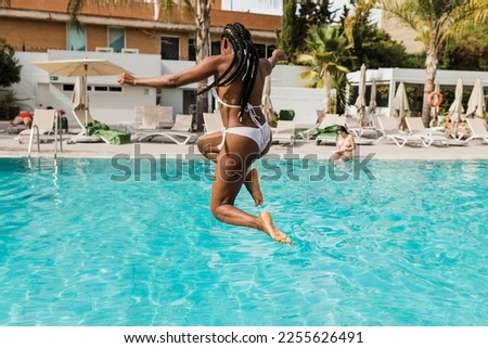 African American woman jumping into pool