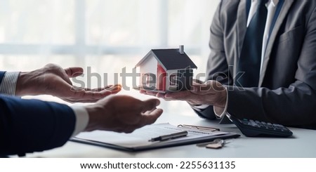 Close up of Real estate agent to buy houses and land are delivering keys and houses. Discussion with a real estate agent