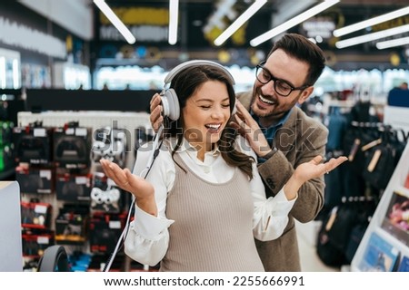 Beautiful and happy middle age couple buying consumer tech products in modern home electronics store. They are choosing high quality hifi audio speakers and audiophiles headphones. Royalty-Free Stock Photo #2255666991