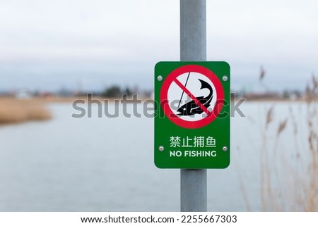 Chinese fishing prohibited sign near the lake - NO FISHING.