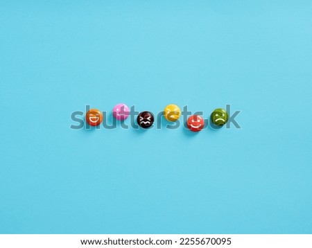 Joy, serenity, anger, happiness, sadness, delight, hate. Psychological mood swings. Variety of human emotions represented by emoticons on colored candies. Royalty-Free Stock Photo #2255670095